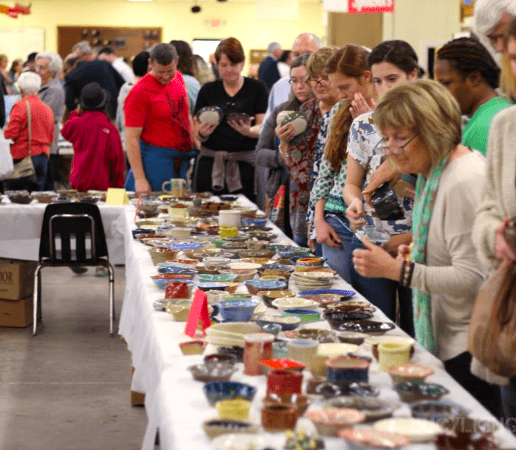 People choosing bowls at the Empty Bowls Fundraiser
